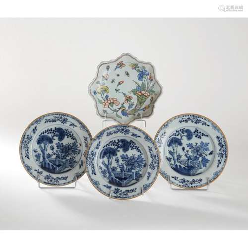 A SET OF FOUR 18th CENTURY FACES, INCLUDING: THREE 18th CENTURY FACES, DELFT, with a blue monochrome decoration of a flowering hedge and a mustard tree covered with a baluster in earthenware with a blue monochrome decoration of factories. Plates marked with an axe.
