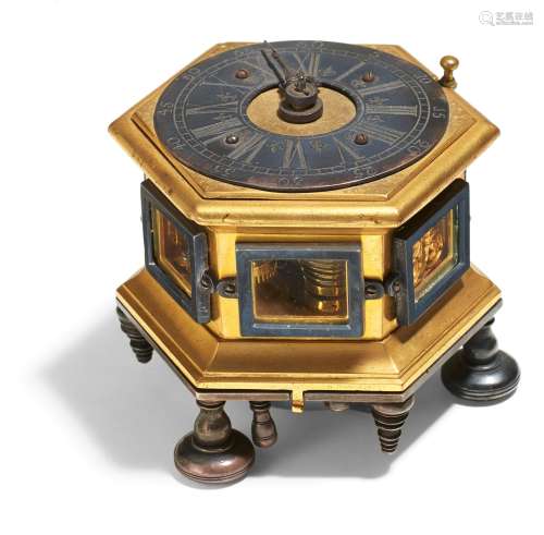HEXAGONAL BAROQUE TABLE CLOCK MADE OF GILT BRONZE WITH RESIDUES OF SILVER PLATING AND GLASS.