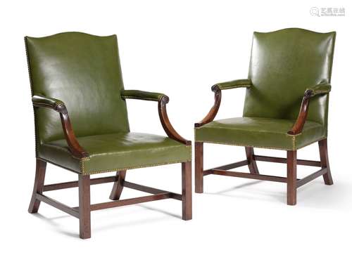 A pair of mahogany and brass studded green leather upholstered armchairs, in George III style, 19th