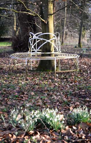 A Regency white painted wrought iron wirework tree seat