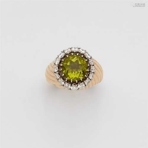 An 18k gold and peridot ringRing band with flaring ribbed borders, the bezel set with a brilliant-