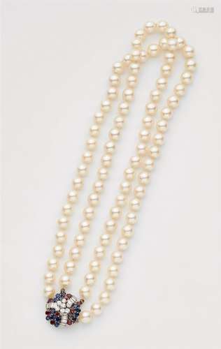 A pearl necklace with a coloured gemstone claspTwo-stranded pearl necklace of 45/43 cultured