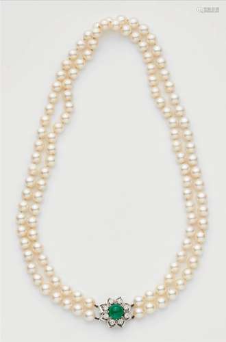 A cultured pearl necklace with an 18k gold diamond and emerald clasp.A two-stranded necklace of 54/