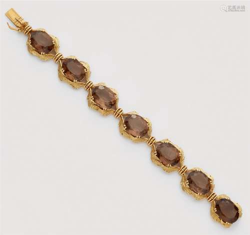 An 18k gold and smoky quartz braceletDesigned as a pierced band of stylised foliage set with seven