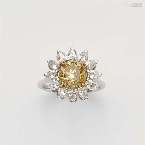 An 18k gold and fancy diamond ring18k white gold ring with a flower-shaped bezel set with a