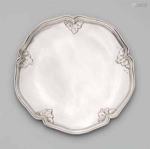 A Dresden Rococo silver platterSilver. A round, scalloped platter, the moulded rim decorated with