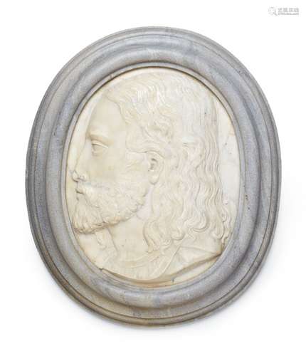 A marble relief plaque with the head of a young manOval white marble plaque depicting a bust of a