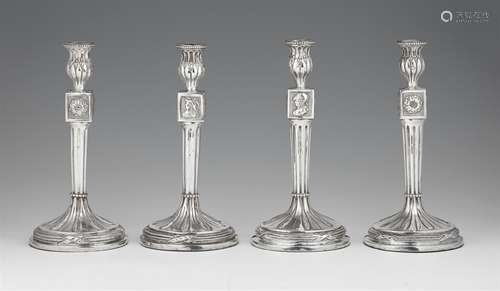 Four Antwerp silver candlesticksTwo near identical pairs of silver candlesticks with fluted column