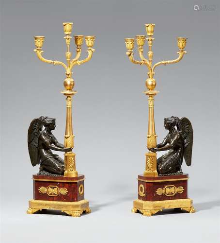 A rare pair of ormolu candelabra with kneeling figures of VictoryFire-gilt and burnished bronze