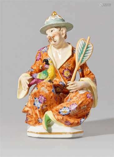 A Meissen porcelain figure of a seated pagode with a parrotMale figure in an exotic hat holding a