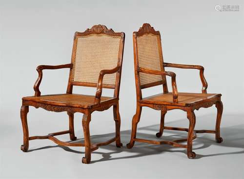 A pair of carved oak “fauteuils à la reine”Red stained oak armchairs with replaced cane