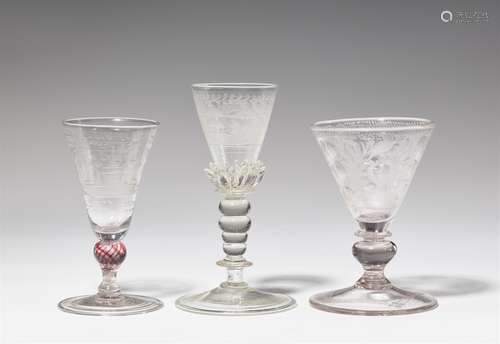 Three Bohemian glass gobletsClear glass goblets, one with round cut motifs, one with red thread