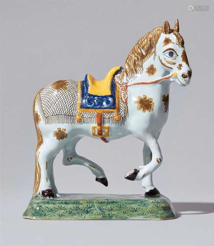 A Delftware faience model of a striding horseA horse with saddle, blanket and bridle on an oblong