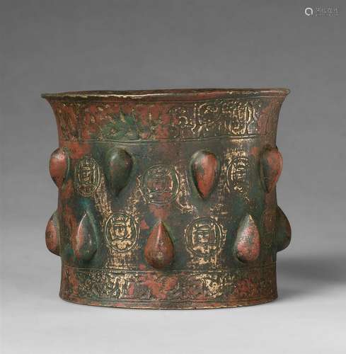 A rare Sanskrit mortarCast and chased bronze with remnants of red pigment. Cylindrical form with