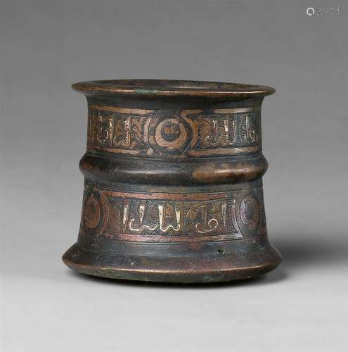 A small Islamic mortarCast bronze with silver plating and copper damascening. Slightly tapering form