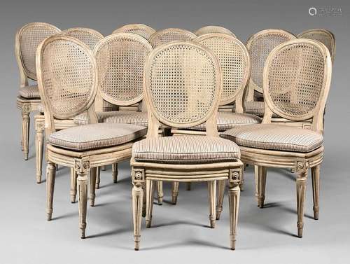 A suite of twelve cane chairs with a white lacquer…