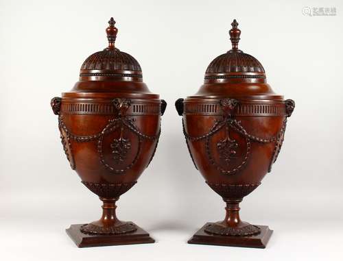 A VERY GOOD PAIR OF CHIPPENDALE DESIGN MAHOGANY CUTLERY URNS, with well carved rising tops, rams