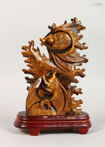 A CHINESE CARVED TIGER'S EYE FISH GROUP on a stand. 8ins high.