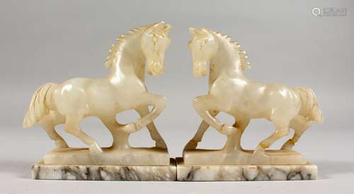 A SMALL PAIR OF CARVED ONYX HORSES, on marble bases. 4.5ins high.