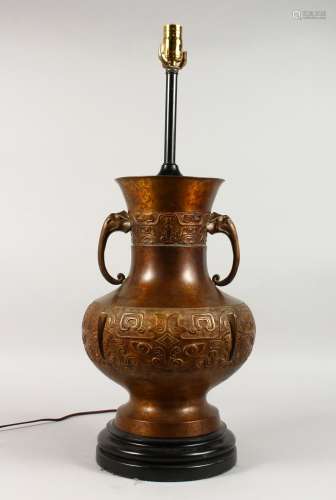 A LARGE CHINESE BRONZE ARCHAIC TWO-HANDLED LAMP, on a circular base. 19ins high.