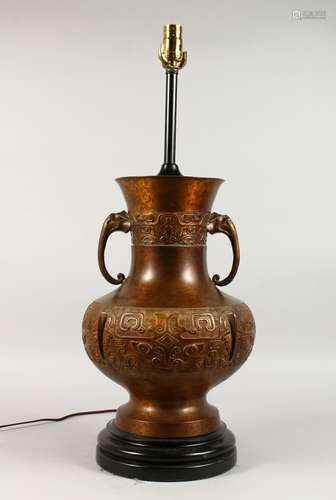 A LARGE CHINESE BRONZE ARCHAIC TWO-HANDLED LAMP, on a circular base. 19ins high.