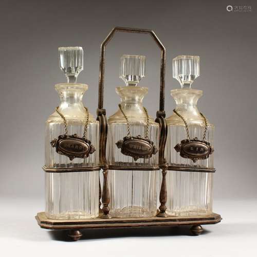 A GOOD THREE BOTTLE CUT GLASS TANTALUS, with three whisky decanters & stoppers and wine labels.