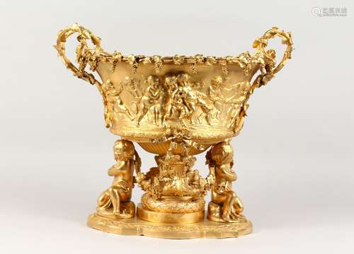 A LARGE GILT BRONZE OVAL WINE COOLER-CENTREPIECE, with cupid design and fruiting vines, on a base