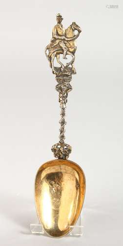 A CONTINENTAL SILVER GILT SPOON, with a cast handle depicting a horse and jockey. 8ins long.