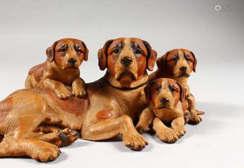 A SUPERB BLACK FOREST CARVED WOOD GROUP OF A DOG AND THREE PUPS. 10.5ins long. See Swiss Carvings,