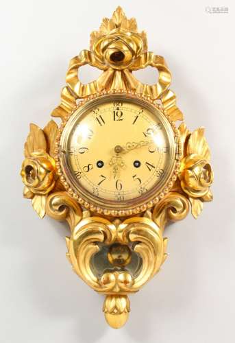 A GOOD GILT WOOD CARTEL CLOCK with circular dial, the case with scrolls and roses. 6.5ins diameter.