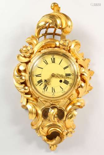 A GOOD GILT WOOD CARTEL CLOCK with circular dial, the case with scrolls and roses. 6ins diameter.
