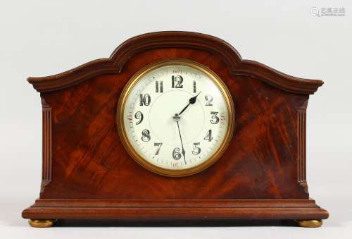 A 1920'S-1930'S WALNUT CASED MANTLE CLOCK, with serpentine top, on four ball feet. 10ins long.