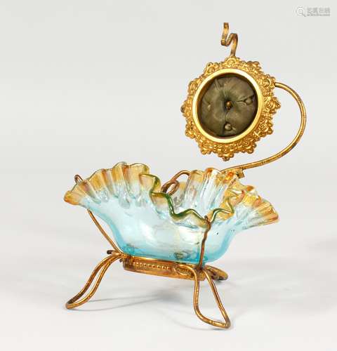 AN ORNATE GILT METAL AND GLASS WATCH HOLDER.