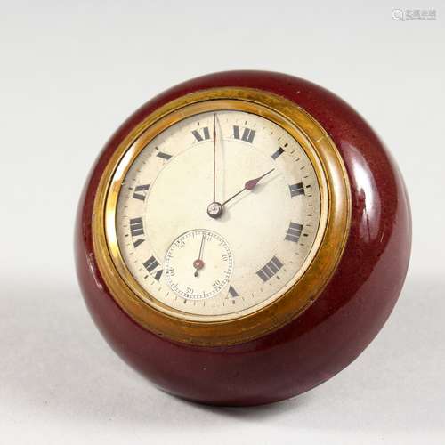 A SMALL CIRCULAR TRAVELLING BEDSIDE CLOCK, with silvered dial and enamel case. 2.75ins diameter.