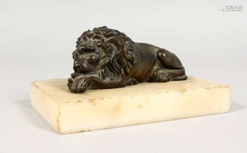 A SMALL CAST BRONZE MODEL OF A RECUMBENT LION, on a marble base. 5ins long.