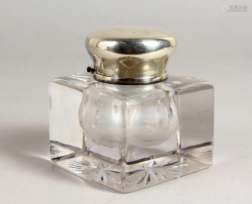 A HEAVY CUT GLASS INKWELL, with hinged silver top. 3.5ins wide.