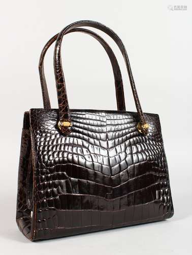 A BLACK CROCODILE SKIN HANDBAG.