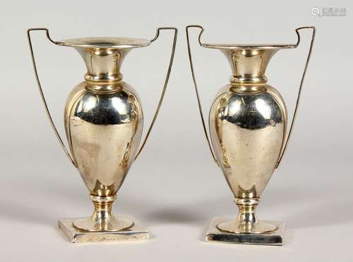 A PAIR OF SILVER TWIN-HANDLED TROPHY STYLE VASES. Birmingham 1912. 5.75ins high.