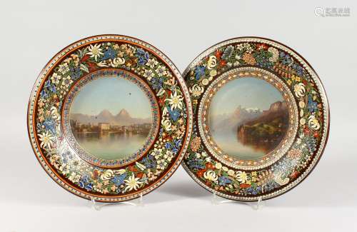 A PAIR OF CONTINENTAL TERRACOTTA CIRCULAR DISHES, each painted to the centre with mountainous