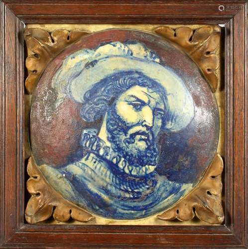 AN ITALIAN MAJOLICA TILE, depicting a man with a beard, wearing a hat, in an oak frame. 14ins wide.