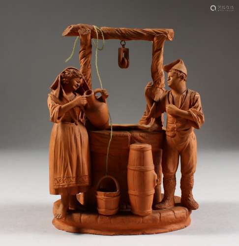 A TERRACOTTA GROUP OF TWO FIGURES STANDING BY A WELL. 6.5ins high.
