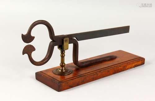 A 19TH CENTURY WROUGHT IRON SUGAR LOAF CUTTER, on wooden base. 14.5ins long.