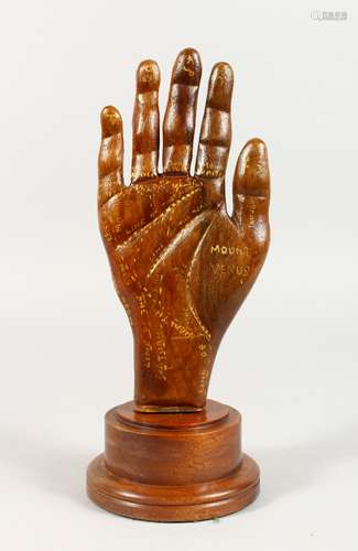 AN UNUSUAL CARVED AND PAINTED PALM READING HAND, on turned wood stand. 10.5ins high.