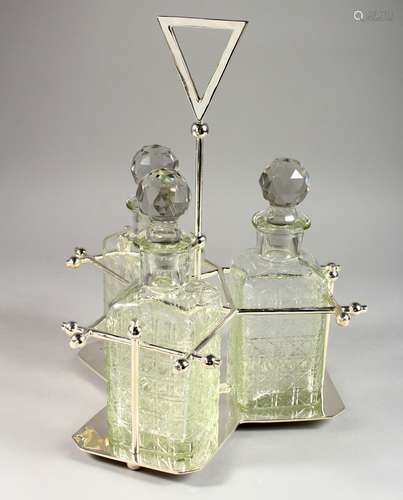 A THREE BOTTLE TANTALUS, in a plated frame.