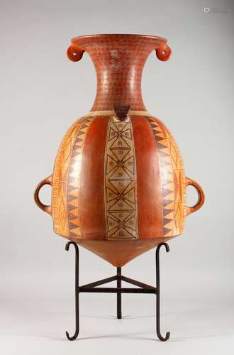 AN EARLY SHIPIBO PERUVIAN AMAZON JUNGLE POTTERY TWO-HANDLED URN. 22ins high, on a metal stand.