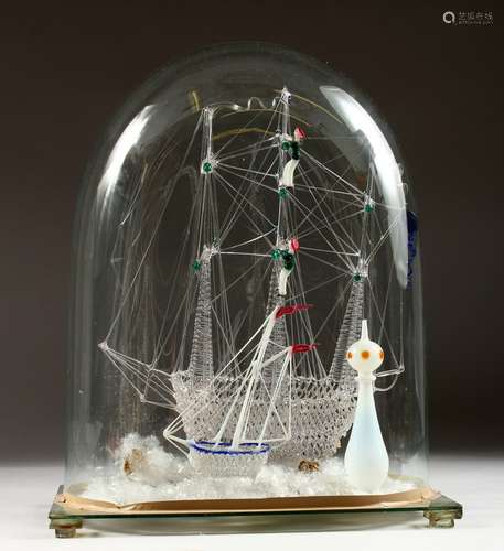 A FINE GLASS MODEL OF A GALLEON; together with a smaller ship and lighthouse, under a glass dome.