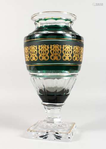 A LARGE AND HEAVY CRYSTAL VASE, with green and gilt band, faceted body, on square base, signed. 15.