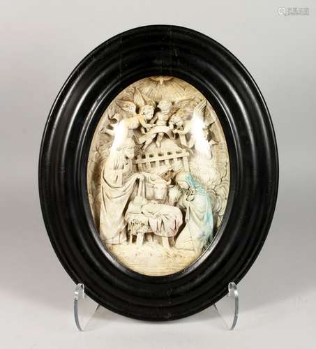 A RELIEF MOULDED PLASTER PLAQUE DEPICTING THE NATIVITY, in an ebonised oval frame. 17ins x 14ins.