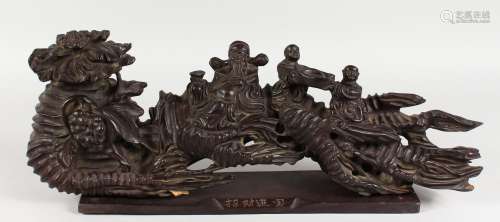 A CHINESE CARVED WOOD GROUP, many figures on a stand. 21ins long.