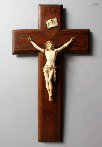 A 19TH CENTURY IVORY CORPUS CHRISTI, mounted on a brass inlaid rosewood crucifix. 13.75ins high.